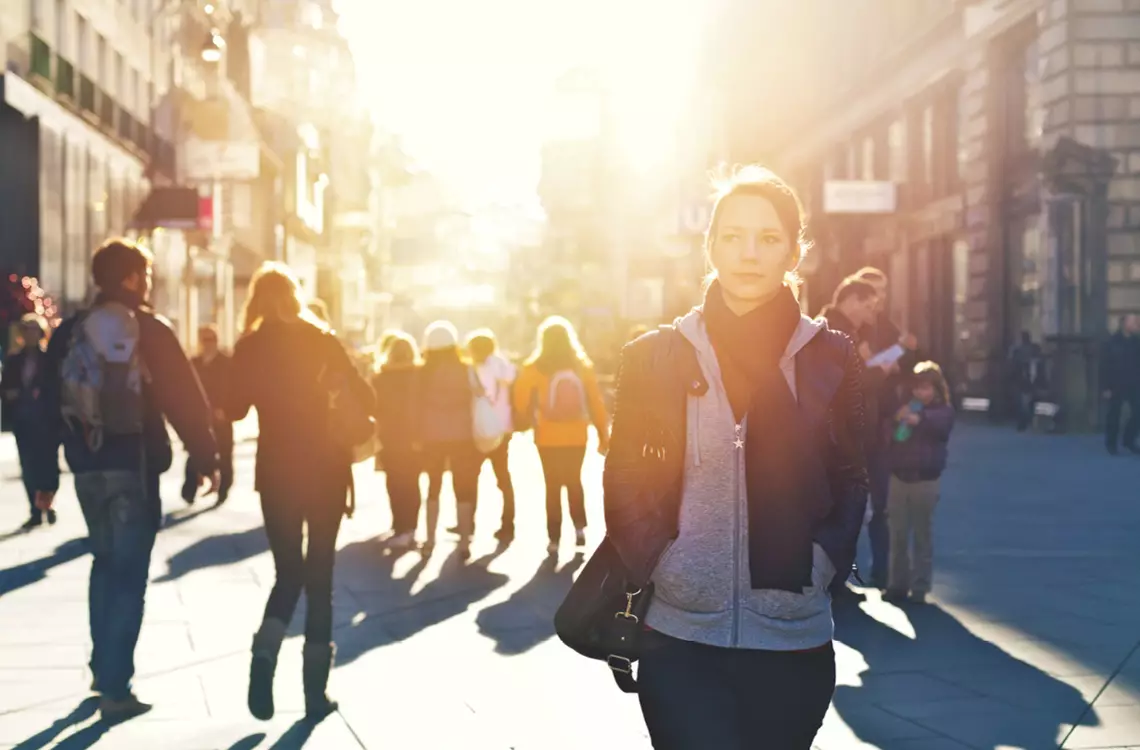 Une jeune fille en premier plan dans une rue fréquentée