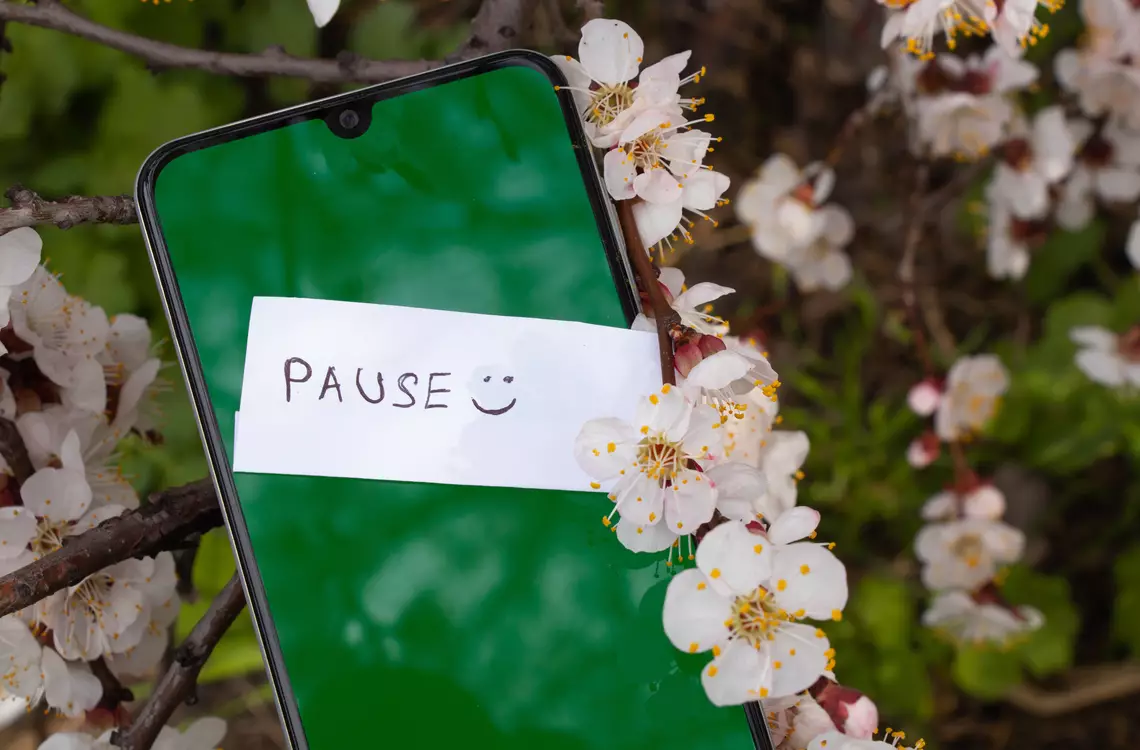 Smartphone avec un mot "Pause :)" dessus