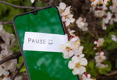 Smartphone avec un mot "Pause :)" dessus